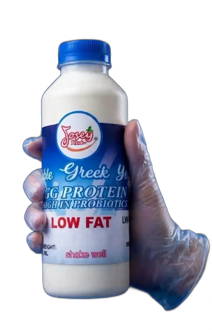 A gloved hand holding a 500 ml bottle of Josey Rich drinkable Greek yoghurt, its blue label reading HIGH IN PROBIOTICS and LOW FAT.