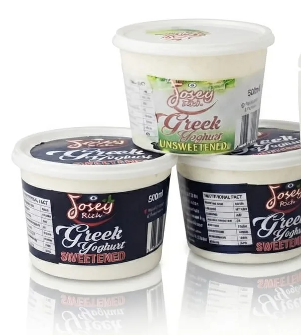 Three Josey Rich Greek yoghurt tubs, two navy sweetened and one green-and-white unsweetened.